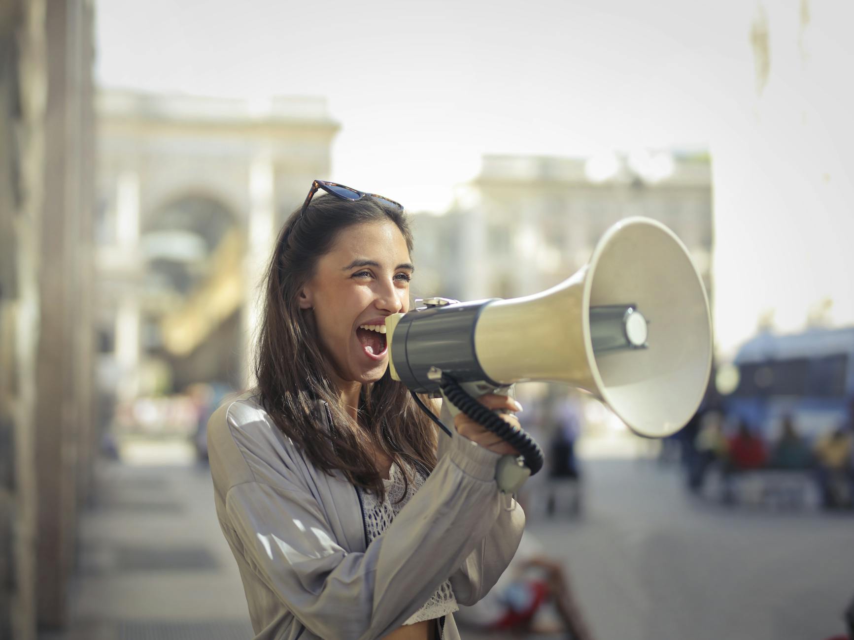 A woman is on the street yelling through a megaphone.