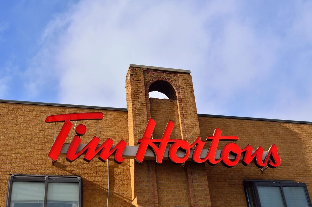 The Tim Horton's sign on the outside of a brick building.