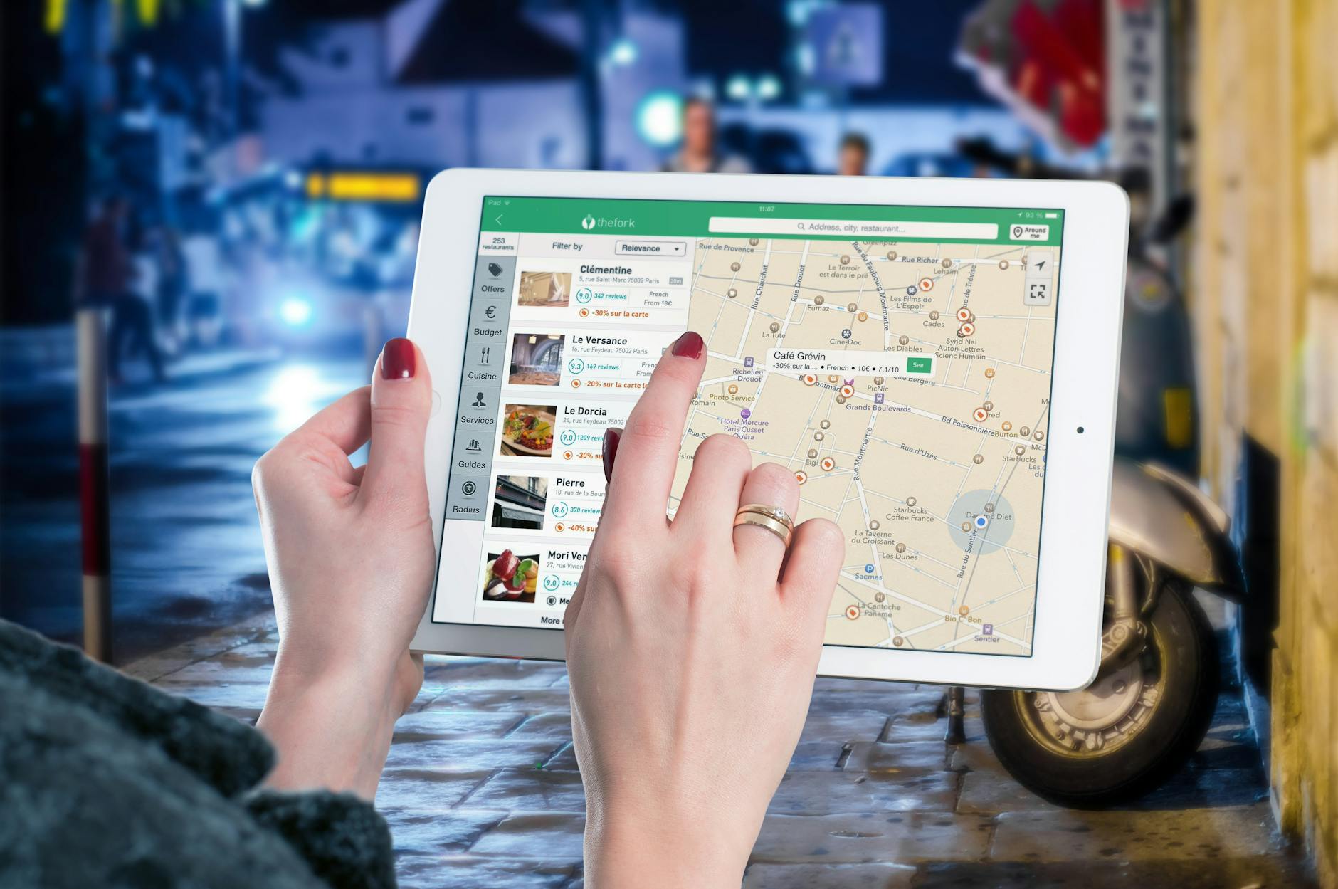 A tablet shows a map and a person is selecting a location.