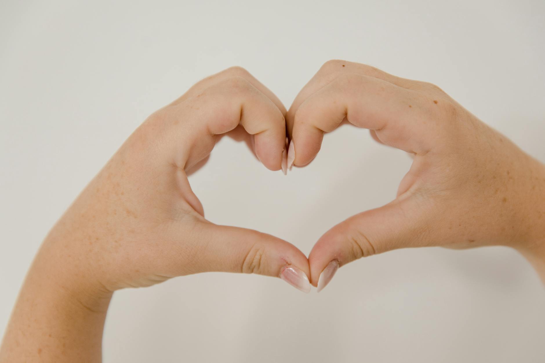 Two hands form a heart symbol with the fingers and thumbs.
