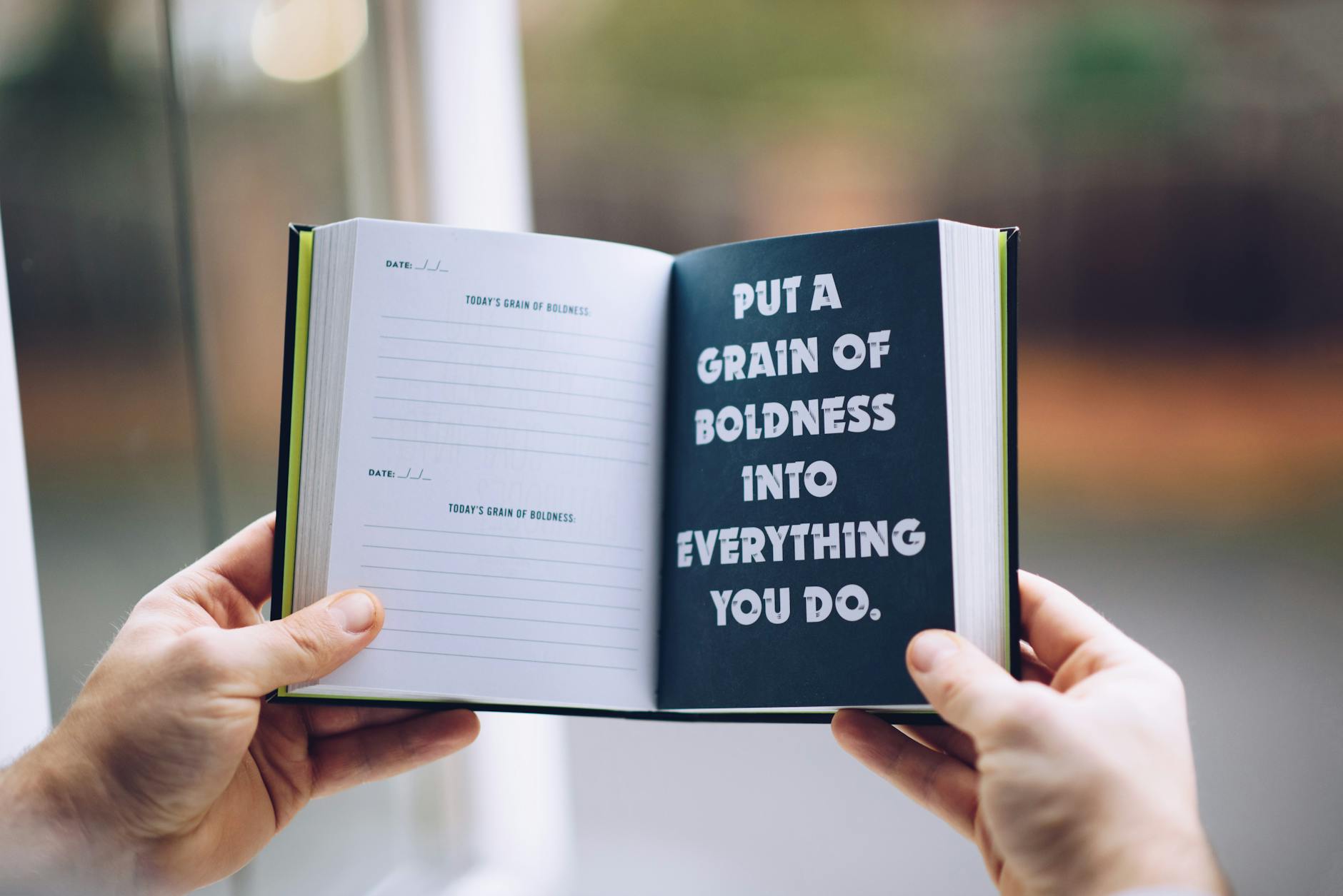 A journal with a page stating, "Put a grain of boldness into everything you do."