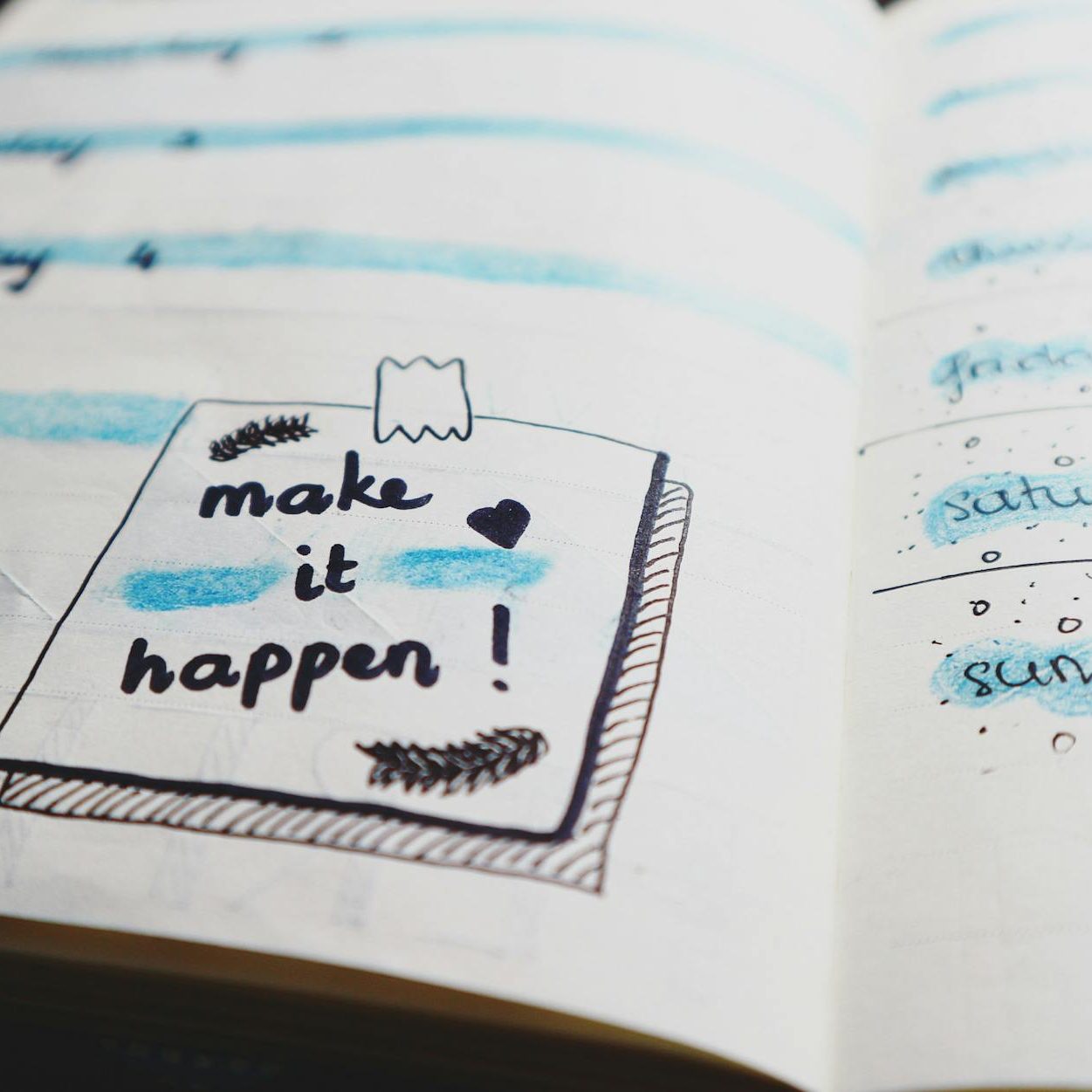 A drawing of a post-it note on a journal says, "Make it happen!"